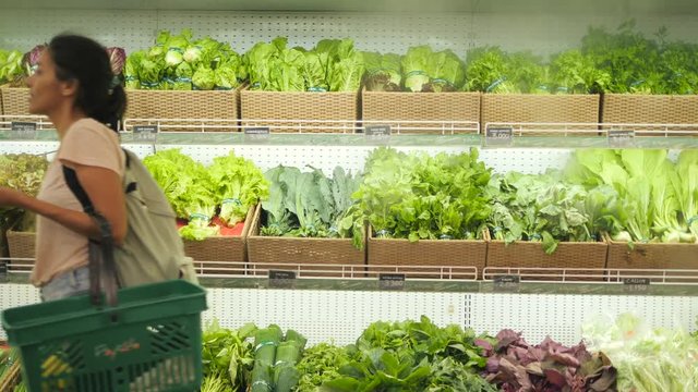 Young Mixed Race Woman Shopping in Grocery Store. Vegan Girl Choosing Fresh Green Salads and Organic Veggies. 4K.