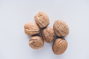 Top view of six walnuts on white surface