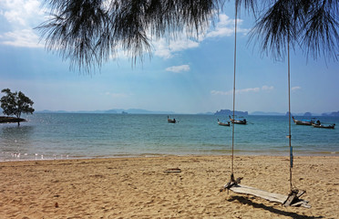 Summer, Travel, Vacation and Holiday concept - Swing hang from tree over beach sea in Khlong Muang Beach, Krabi,,Thailand.
