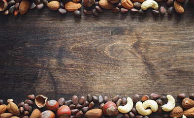 Different nuts on a wooden table. Cedar, cashew, hazelnut, walnu