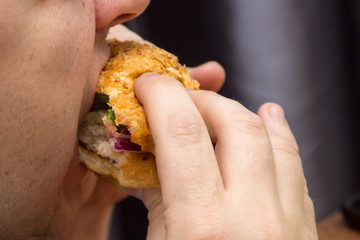 Close Up Of Man Hands Holding Delicious Burger and eating it