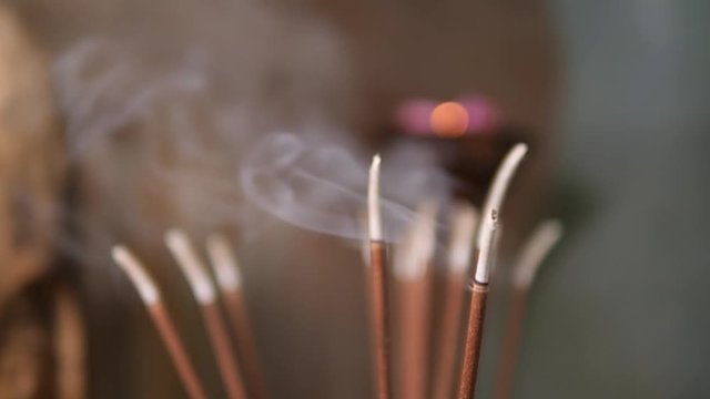 Incense Sticks Burning and Making Beautiful Smoke on the Table in Yoga Practice Room. 4K, Slowmotion.