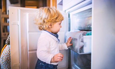 Toddler boy in dangerous situation at home. Child safety concept.