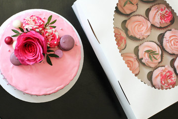Obraz na płótnie Canvas Tasty pink homemade cake decorated by rose and macarons