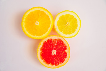Citrus fruits on a white background. Grapefruit, lemon and orange in a cut. View from above