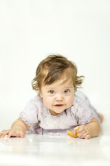 The little girl is eating a bagel. The concept of a healthy baby food. white background