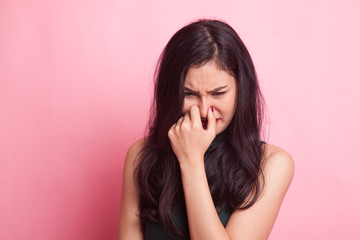 Young Asian woman  holding her nose because of a bad smell.