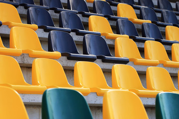 Rows of plastic black and yellow seats at a stadium