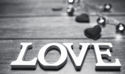 word love made up of white wooden letters on a wooden background