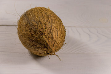 Whole coconut on white wooden table