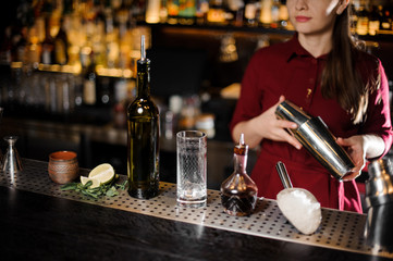 Female bartender shaking a cocktail on the bar counter