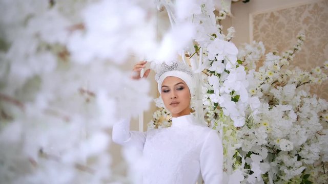 Beautiful muslim bride in white wedding dress and bridal headdress