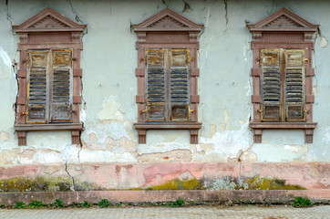 Fototapeta na wymiar Dilapidated house with broken windows and shutters