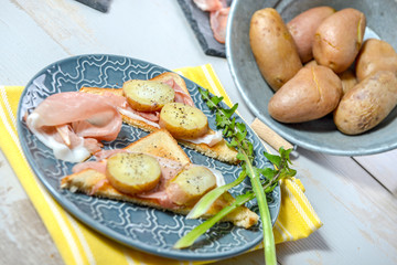 slices of ham and potatoes in blue dish