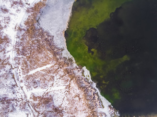 marsh lake and shore from above, aerial survey, in winter, snow-covered day, background image