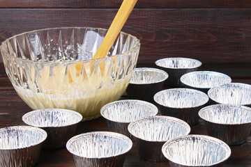 Molds for muffins on a wooden table.