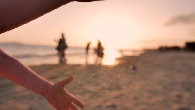 Sea sand running through a child hands.