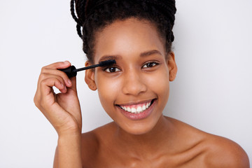  attractive african woman applying  mascara on her eyelashes