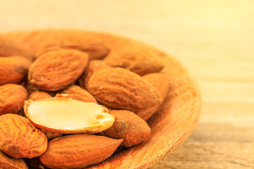 Almonds in the wooden bowl on the table.