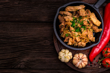Fried pork in frying pan and vegetables