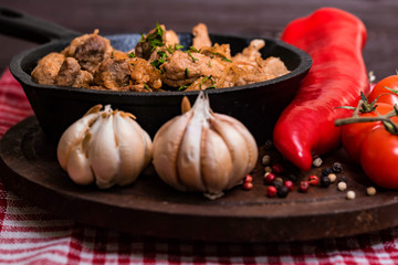 Fried pork in frying pan and vegetables