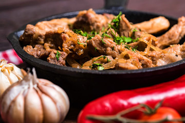 Fried pork in frying pan and vegetables