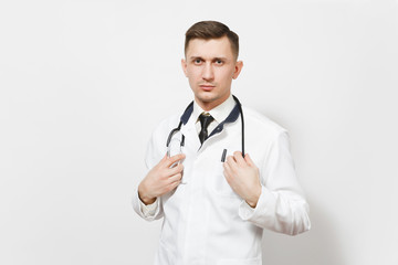 Serious confident experienced handsome young doctor man isolated on white background. Male doctor in medical uniform, holding stethoscope looking camera. Healthcare personnel, health, medicine.