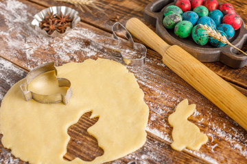 Still life on a wooden background with unusually painted quail eggs and forms for baking curly cookies.