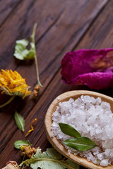 Obraz na płótnie Canvas SPA concept: composition of spa treatment with natural sea salt, aromatic oil and flowers on wooden background
