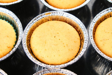 Ready baked muffins on a wooden table.