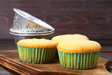 Ready baked muffins on a wooden table.
