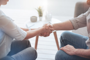 First meeting. Pleasant nice friendly people shaking hands and greeting each other while meeting for the first time