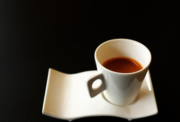 hot espresso in white cup on black background