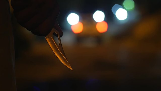 A MAN WALKS AT NIGHT HOLDING A KNIFE - ROBBERY, VIOLENCE