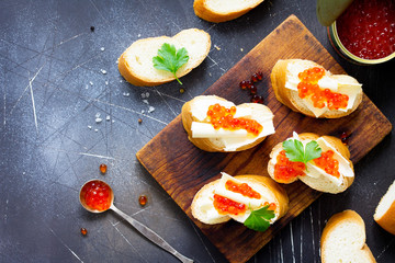 Festive snack. Sandwiches with red caviar, isolated on dark concrete background. Copy space, top view flat lay background.