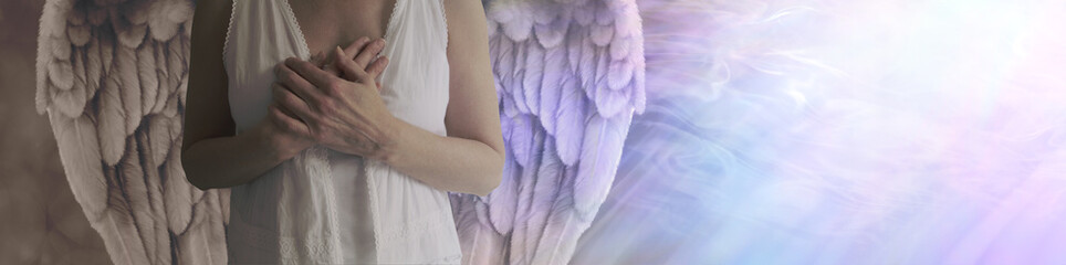 There is dark and light in all - Angel showing torso in white robes with hands held over heart with left side shaded in darkness and right side lit by a stream of heavenly white light

