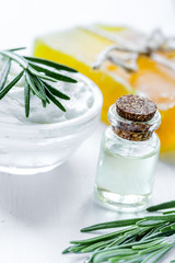 homemade cosmetics with rosemary herbs on white wooden backgroun