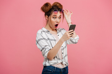 Portrait of a shocked young girl using mobile phone