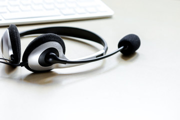Office desk with headset and keyboard brown background mockup