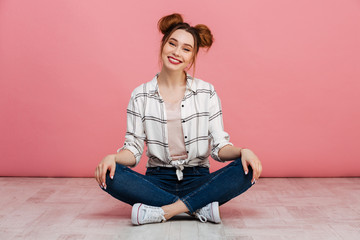 Portrait of a happy young girl sitting on a floor