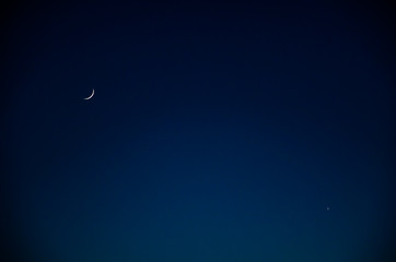 thin month and star in the night sky