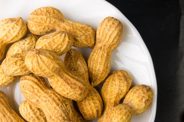 Peanuts in shell on dark background, close up