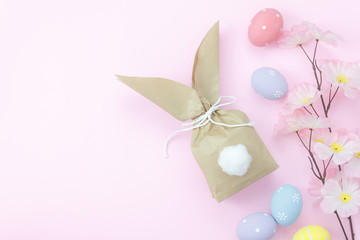 Top view shot of arrangement decoration Happy Easter holiday background concept.Flat lay colorful bunny bag paper with accessory ornament eggs on modern pink paper at office desk.Design pastel tone.