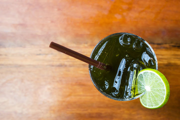 Glass of ice lemon green tea on wooden table. Top view with copy space.  Freshness beverage. Decorate glass with slice lemon.