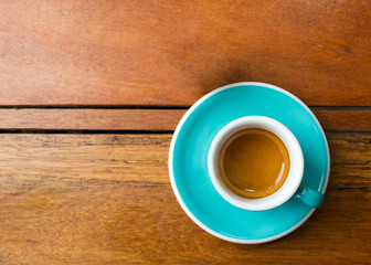 Hot espresso in blue cup on wooden table. Favorite caffeine beverage.