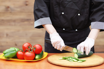 The cook cuts fresh farm vegetables