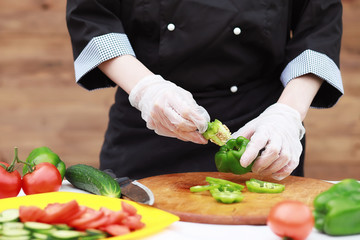 The cook cuts fresh farm vegetables