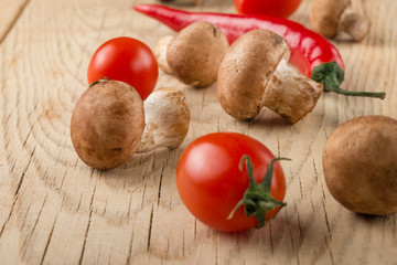 Royal champignons with rosemary and vegetables. On a wooden texture. Macro.