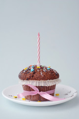 One Birthday Muffin, Cupcake with Candle, on Grey Blue background. Pink bow. Isoalted.
