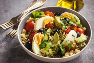Bulgur salad with eggs, avocado, tomatoes and olives.